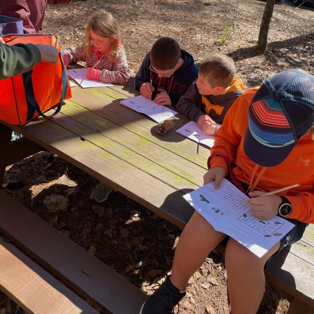 day trip to Congaree National Park with kids, kids at table with Jr Ranger booklets